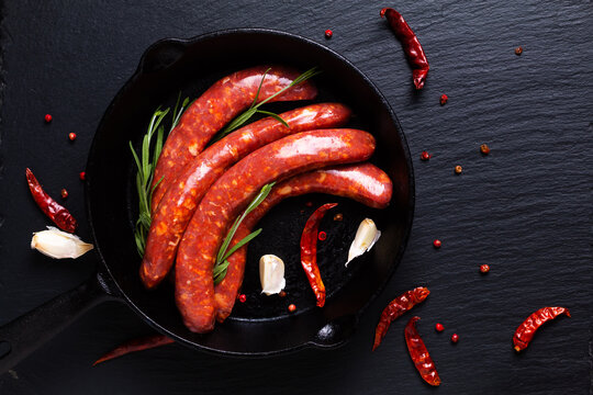 Food concept Merguez French spicy sausages in skillet iron pan with copy space