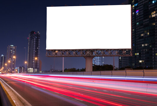 Blank billboard on light trails, street and urban in the night - can advertisement for display or montage product or business.