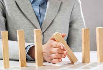 Business woman hand stop domino effect