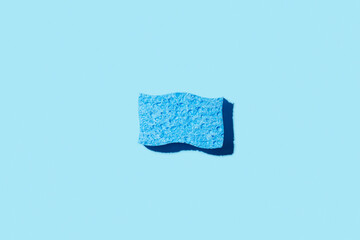 Creative layout with sponge for dishwashing on blue background