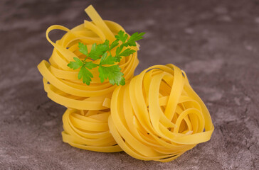 Fresh italian tagliatelle pasta on a gray background.
Close-up.