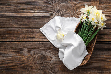 Basket with beautiful daffodils on wooden background