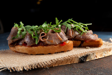 bruschetta with meat and arugula. Selective focus