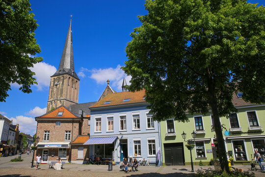 Viersen (Suchteln), Germany - May 20. 2021: View over square on medieval houses and shops with church tower background