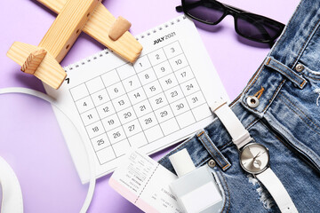 Calendar, ticket and travel accessories on color background, closeup