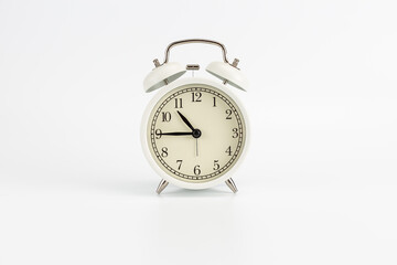 White retro clock alarm clock on white background shows 10:45 am or 10:45 pm or 22:45