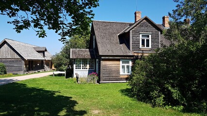 Fototapeta na wymiar Old wooden houses on the territory of the Pastaris Ethnographic Museum in Latvia on August 16, 2020