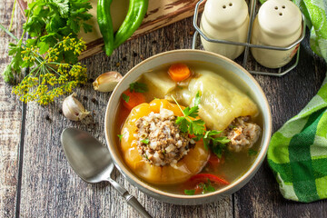 Healthy food, keto diet, lunch. Bell pepper with meat and bulgur in a broth with vegetables in a bowl on a rustic table.. Copy space.