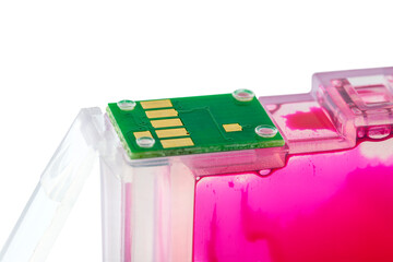 Macro photo of a magenta ink cartridge for a printer with visible contacts on a circuit board,...