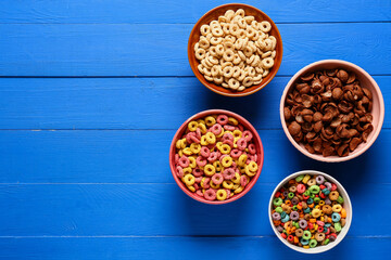Obraz na płótnie Canvas Bowls with cereal rings on color wooden background