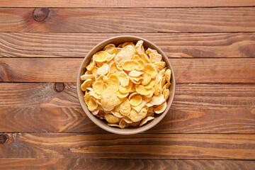 Bowl with corn flakes on wooden background