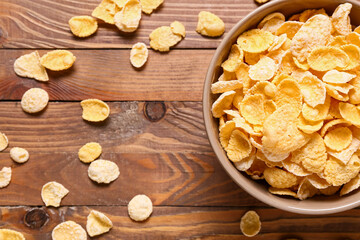 Bowl with corn flakes on wooden background, closeup