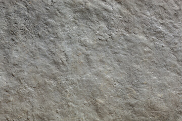 Grey textured and weathered stone wall