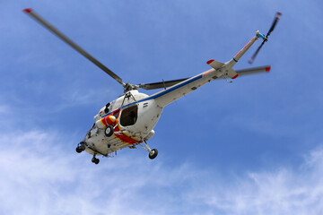 Helikopter policyjny w akcji poszukiwawczej na niebie.
