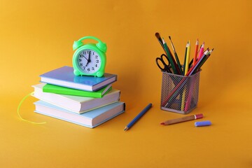 Fototapeta premium Books, alarm clock, stationery on the table, education concept, back to school