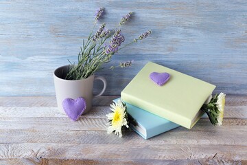 Stack of books, flowers, lavender bouquet, hearts on a wooden table, romantic concept, education,...