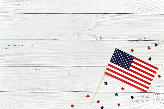Happy 4th of July background mockup with USA flag and red and blue stars on washed wood surface.