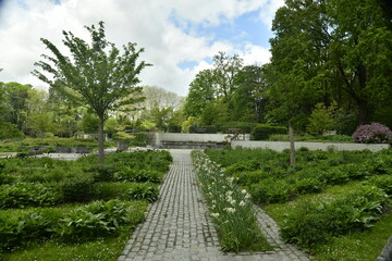 Fototapeta na wymiar Chemin en pavés entre les décoration florales aux Jardin du Fleuriste à Laeken
