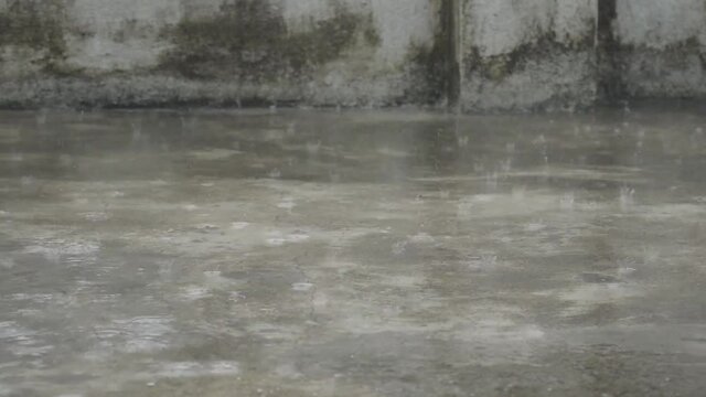 Monsoon rain falling on roof surface of a residential building. Torrential Rain raindrops of water in Summer. Beautiful rainy season. Nature background. Stock Footage. Focus on foreground.