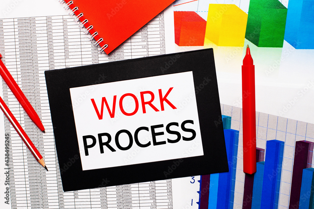 Poster reports and color charts are on the table. there are also red pens, pencil and paper in a black fram
