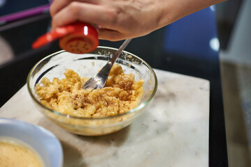 close-up of a woman's hands dressing banana paste with cinnamo