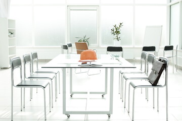 Flipchart construction helmet chairs briefcase phone handle glass table in office space