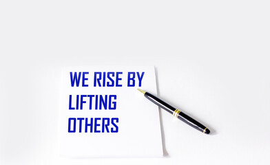 Quote with inscription on a white notebook about the life and work we raise by helping others