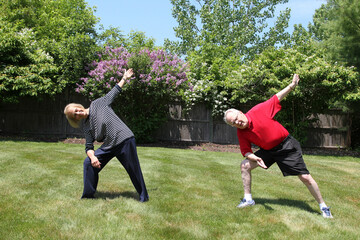 Senior 80-year-old couple doing yoga at backyard