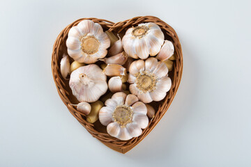 Garlic Cloves and Bulb in Heart Basket on White Background