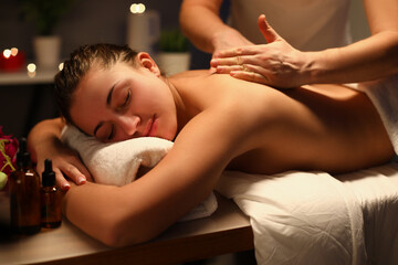 Young woman relaxing during back massage at spa