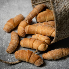 Baked dough bagels. Delicious shortbread rolls spilled out of basket onto table. Pastry sweets or dessert. food concept. Square format. Soft focus.