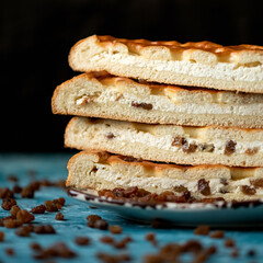 Curd pie, Stack of cut pieces on plate. Homemade pie with cottage cheese and raisins. Cooking process. Close up shot. Soft focus. Side view. Copy space. 