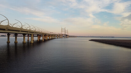 Aerial view of the cable-stayed bridge and autobahn over the bay at sunset
