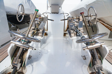 Bow of teak deck, luxury yacht with stainless steel winches and anchor chain fixing mechanisms.