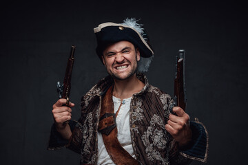Angry corsair with pistols against dark background