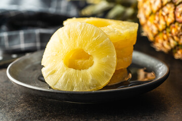 Canned sliced pineapple fruit on plate.