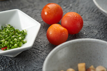tomates pequeños rojos en una mesa rustica negra