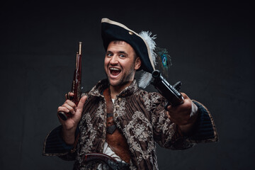 Crazy pirate with boarding pistols against dark background