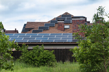 Solar panel on roof, green tree and cloud sky