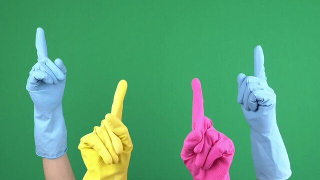 Many hands with protective rubber gloves rise up and fingers point upwards over empty chroma key green screen background. Hand gesture. 4 k video