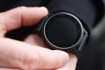 Fototapeta na wymiar Man pressing button on black smart watch closeup