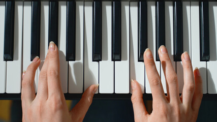 Girl playing piano. Close-up view.