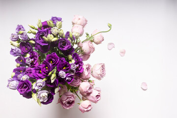 A bouquet of pink and purple flowers with buds on a white background.