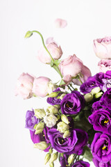 Close-up of a bouquet of bluebells and roses on a white background.