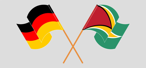 Crossed and waving flags of Germany and Guyana