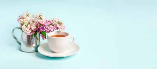 Obraz na płótnie Canvas Beautiful minimalist background with floral composition and tea mug, copy space on light blue backround