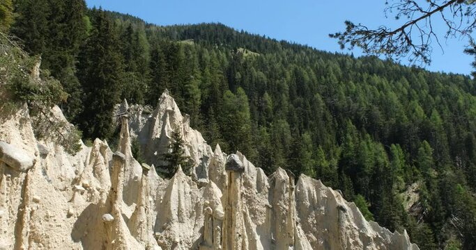 The incredible earth pyramids of Perca (Piramidi di Terra) in the Dolomites. Striking place in the Italian Alps. Sunny spring day. Tilt up. Trentino Alto Adige. 4K UHD 59.94fps ProRes 422 HQ 10 bit