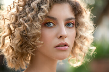 Fototapeta premium Portrait of Beautiful Fashion Model with Wavy Curly Hair and Colored Make-up. Make up and Hair. Haircare concept.