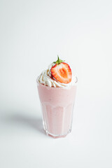 Glasses of fresh strawberry milkshake, Summer drink shake with slice of strawberry on bright background