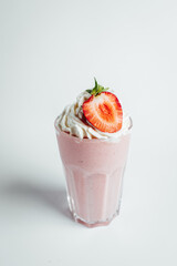 Glasses of fresh strawberry milkshake, Summer drink shake with slice of strawberry on bright background